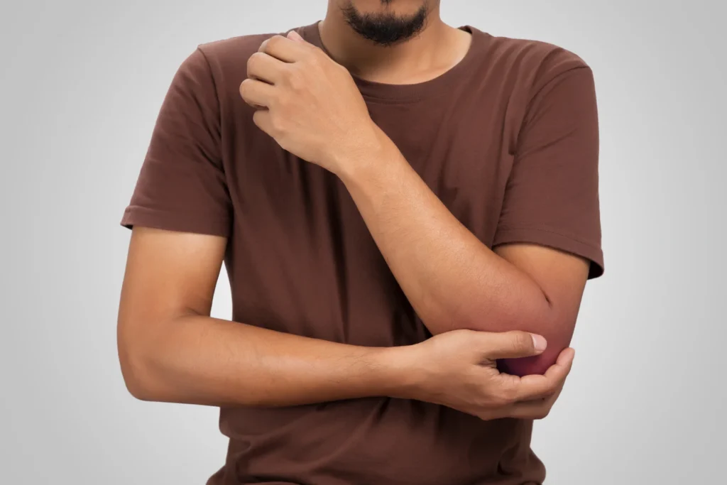man with elbow pain wearing a brown shirt 2026 09 23 05 36 39 utc